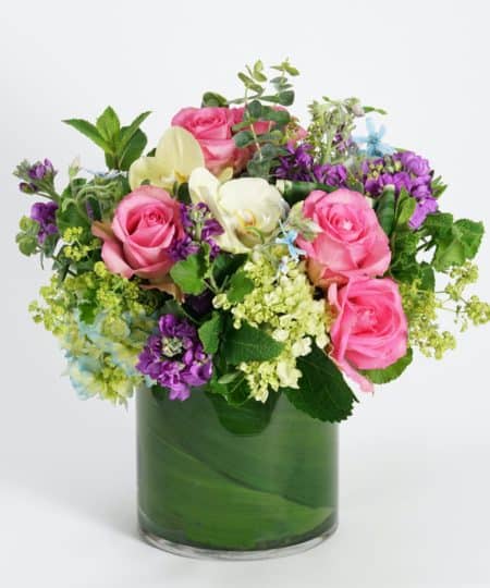 Fresh picked hydrangea, roses, and orchids in lovely shades of soft blue, pink and lavender are complemented by delicate accents of tweedia, geranium and eucalyptus.