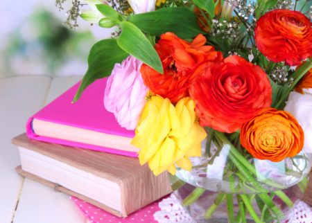 3 books on table with flowers on top