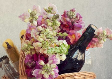 gift basket with bottle of wine and pastel colored flowers
